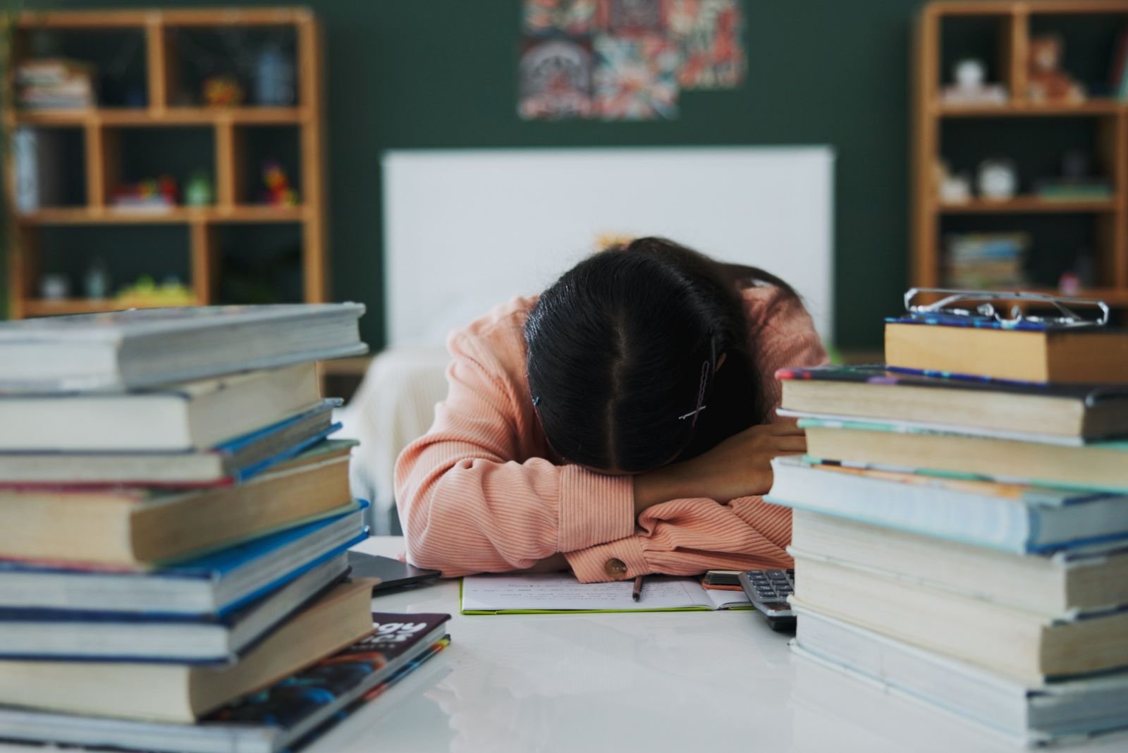 Burnout em adolescentes e estudantes Estudante exausto com livros e apontamentos, num contexto de burnout académico